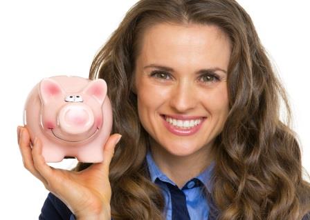 Portrait of smiling business woman showing piggy bank