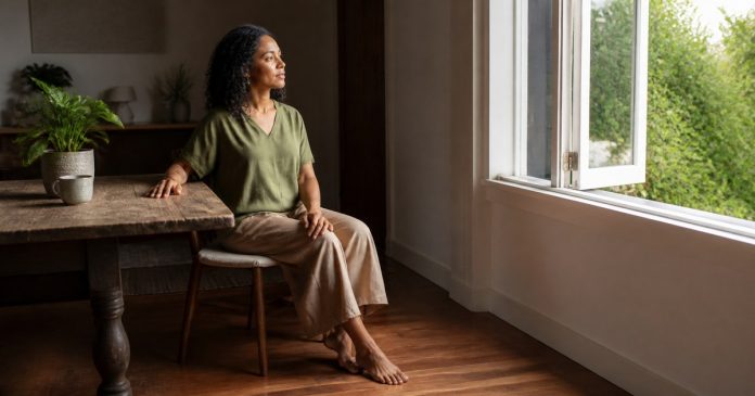 Grounding vs. Spiritual Escapism: How to Tell the Difference Person using a five-senses grounding practice beside an open window